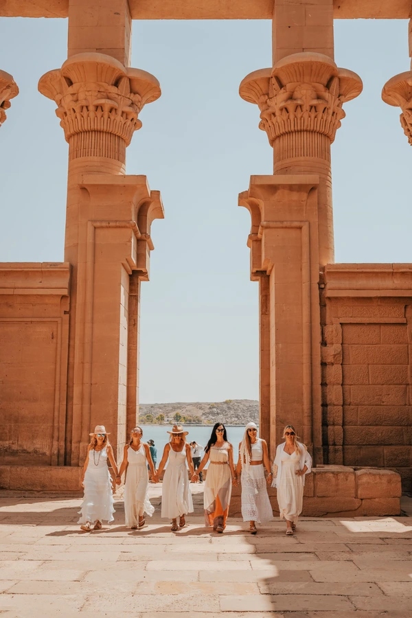 Women walking through Egyptian temple columns