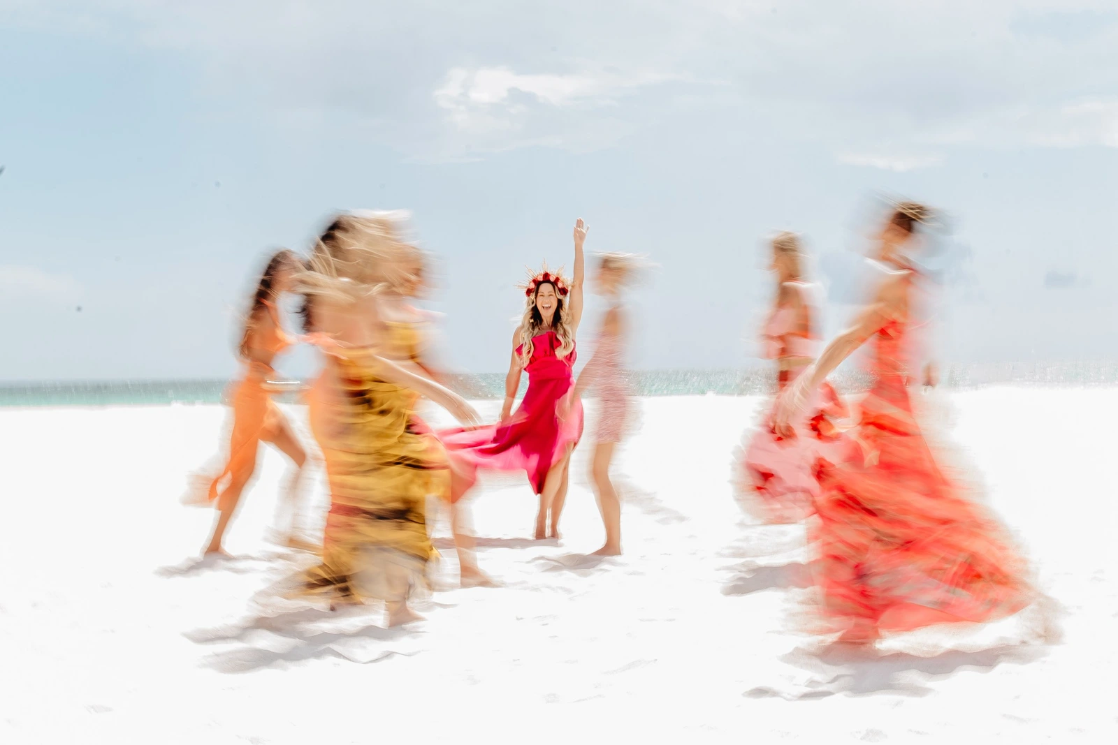 Vanessa Lambert laughing with arm raised, women in motion around her on the beach