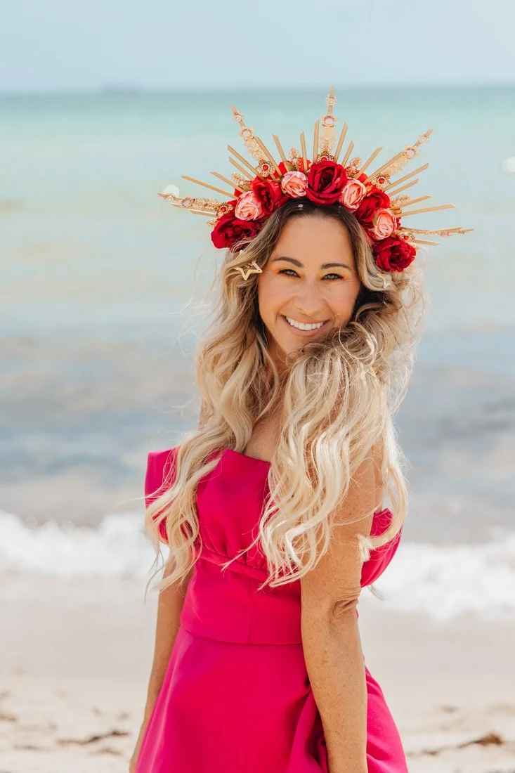 Vanessa smiling in the flower crown on the beach